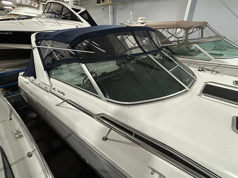 Slide: The Image of 1992 Sea Ray 370 Sundancer boat in storage, featuring a sleek design and blue canopy. - 19