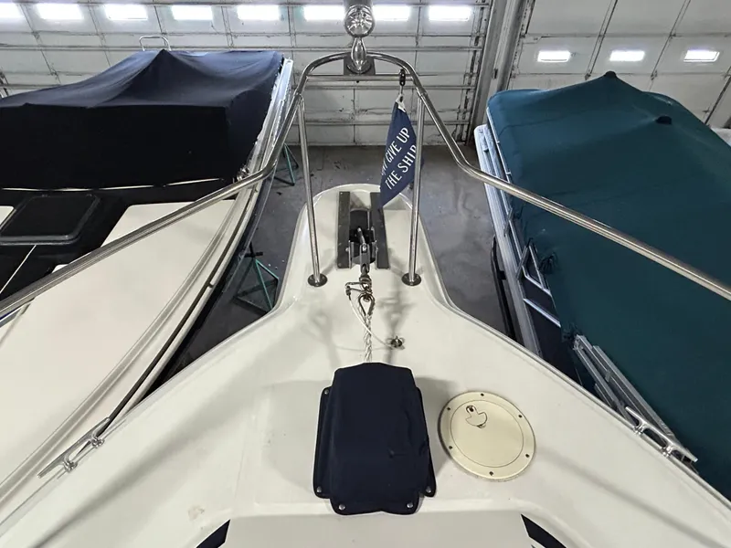 Slide: The Image of 1992 Sea Ray 370 Sundancer bow view in storage, surrounded by covered boats. - 20