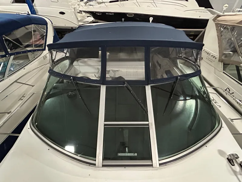 Slide: The Image of 1992 Sea Ray 370 Sundancer boat with blue canopy and windshield, docked among other boats. - 33