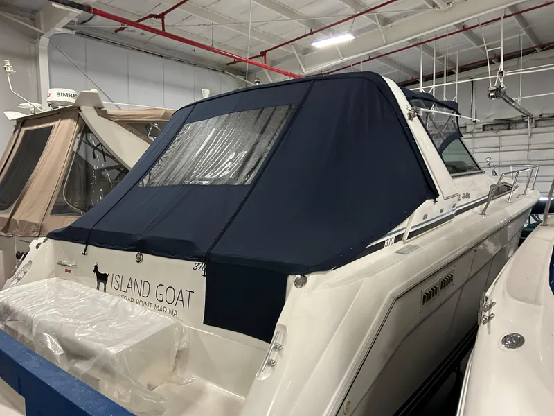 Slide: The Image of 1992 Sea Ray 370 Sundancer yacht with blue cover in indoor storage. - 34