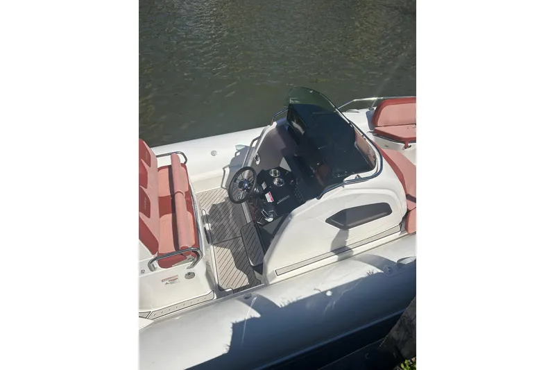 Slide: The Image of 2026 Zodiac Medline 9 boat interior with steering console and seating, docked on water. - 13