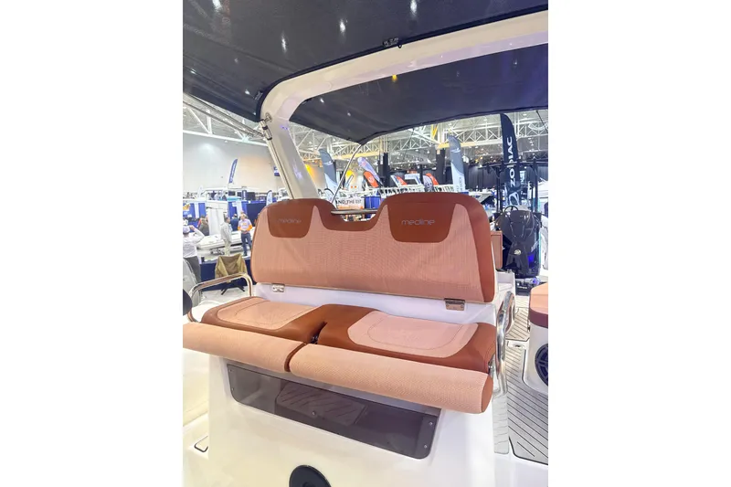 Slide: The Image of 2025 Zodiac Medline 9 boat interior with cushioned seating at a boat show. - 4