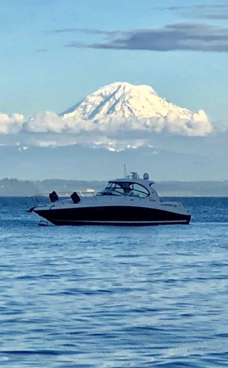 The Image of 2007 Sea Ray 40 Sundancer yacht on calm water with a snow-capped mountain backdrop. - 0