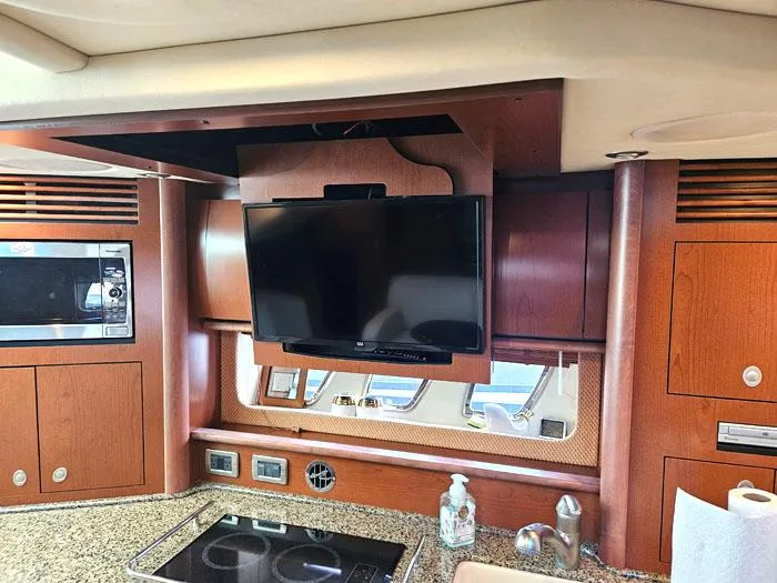 Slide: The Image of Interior of 2007 Sea Ray 40 Sundancer with TV, microwave, and kitchen amenities. - 11