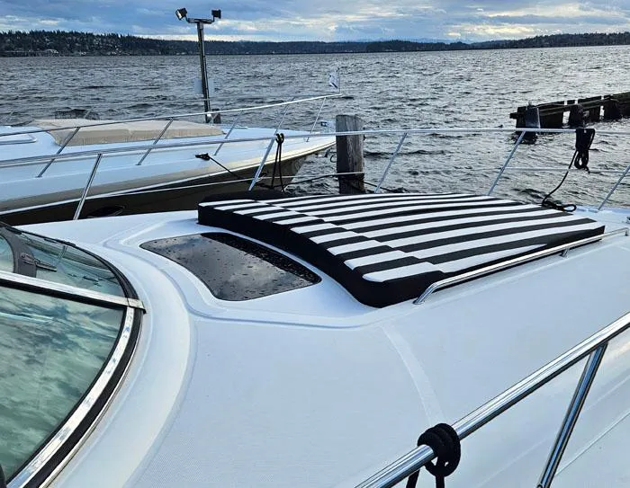 Slide: The Image of 2007 Sea Ray 40 Sundancer yacht with striped sun pad on deck, docked by the water. - 4