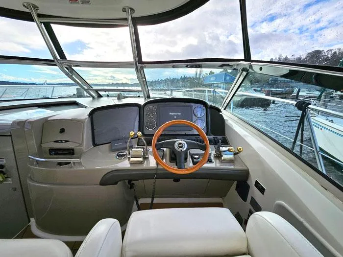 Slide: The Image of 2007 Sea Ray 40 Sundancer helm with wooden steering wheel and modern controls. - 8