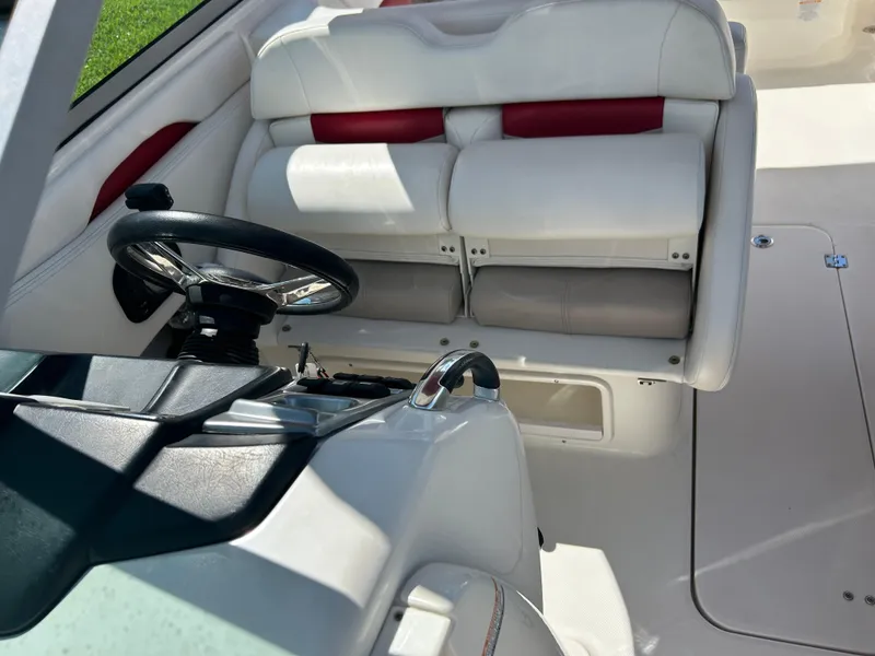 Slide: The Image of 2015 Chaparral 287 SSX boat interior with white and red seating, steering wheel, and controls. - 11