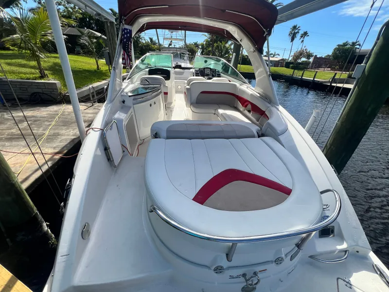 Slide: The Image of 2015 Chaparral 287 SSX boat with spacious seating and sleek design docked by the water. - 2