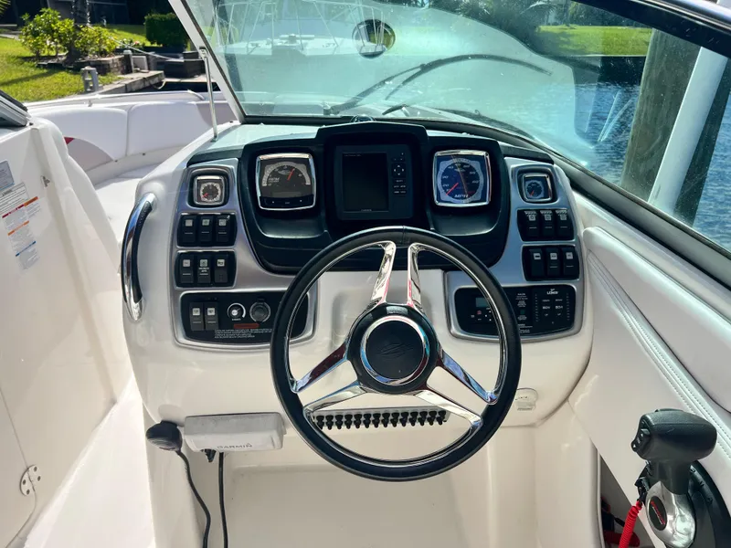 Slide: The Image of 2015 Chaparral 287 SSX boat dashboard with steering wheel and control panels. - 7