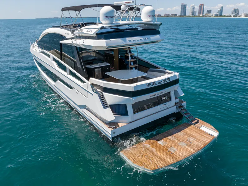 Slide: The Image of Galeon 650 Sky 2019 yacht cruising near Miami Beach, featuring spacious deck and modern design. - 15
