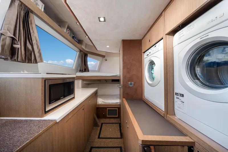 Slide: The Image of Laundry area in 2019 Galeon 650 Sky yacht with washer, dryer, and microwave. - 42