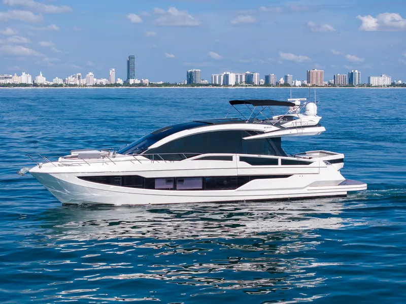Slide: The Image of 2019 Galeon 650 Sky yacht cruising near city skyline on a sunny day. - 5