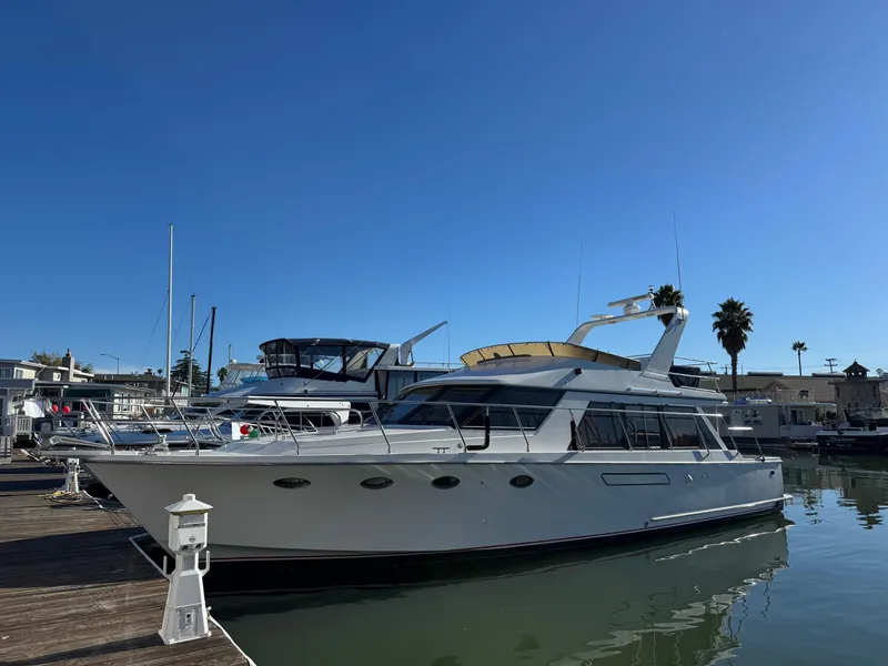 Slide: The Image of 1991 Ocean Alexander 46 yacht docked in a marina under clear blue skies. - 0