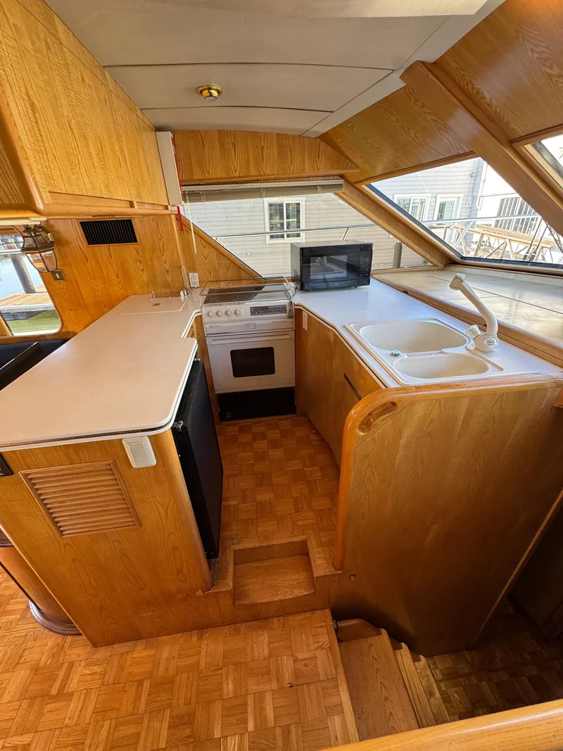 Slide: The Image of Interior of 1991 Ocean Alexander 46 yacht kitchen with wood cabinetry and modern appliances. - 7