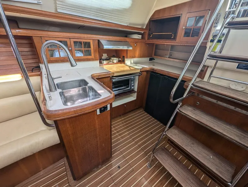 Slide: The Image of 2007 Hunter 45 CC yacht interior with wooden cabinetry and modern kitchen amenities. - 17