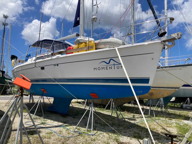 Slide: The Image of 2007 Hunter 45 CC sailboat on stands, named "Momentum," under a blue sky. - 3