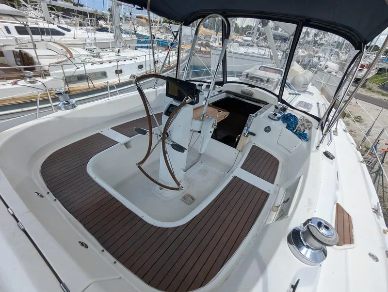 Slide: The Image of 2007 Hunter 45 CC sailboat cockpit with wooden flooring and steering wheel. - 8
