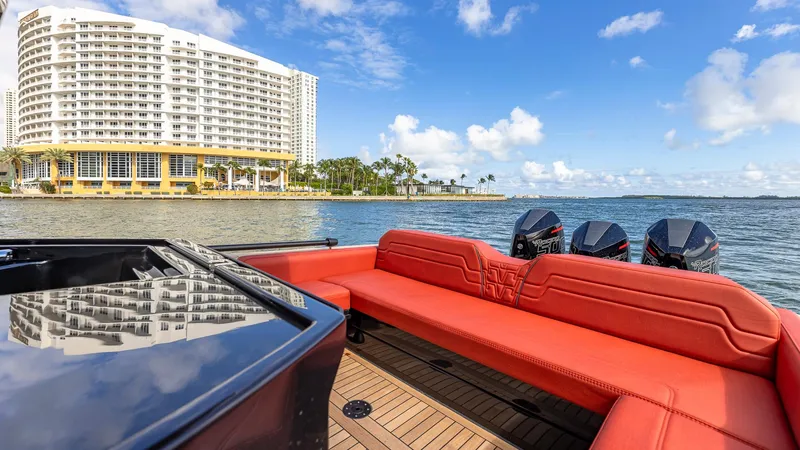 Slide: The Image of Technohull Omega 47 (2025) with red seating, scenic waterfront view, and modern architecture. - 13