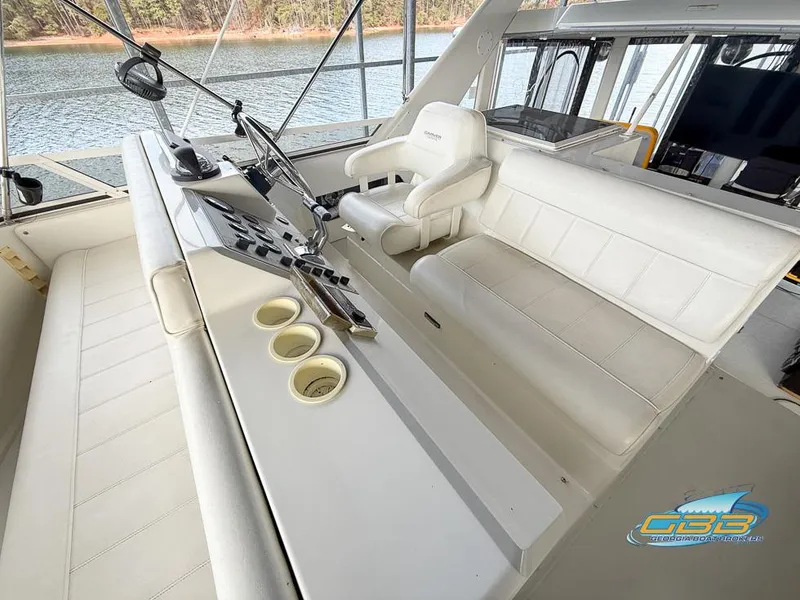 Slide: The Image of 1998 Carver 405 Aft Cabin yacht helm with white seating and control panel. - 22