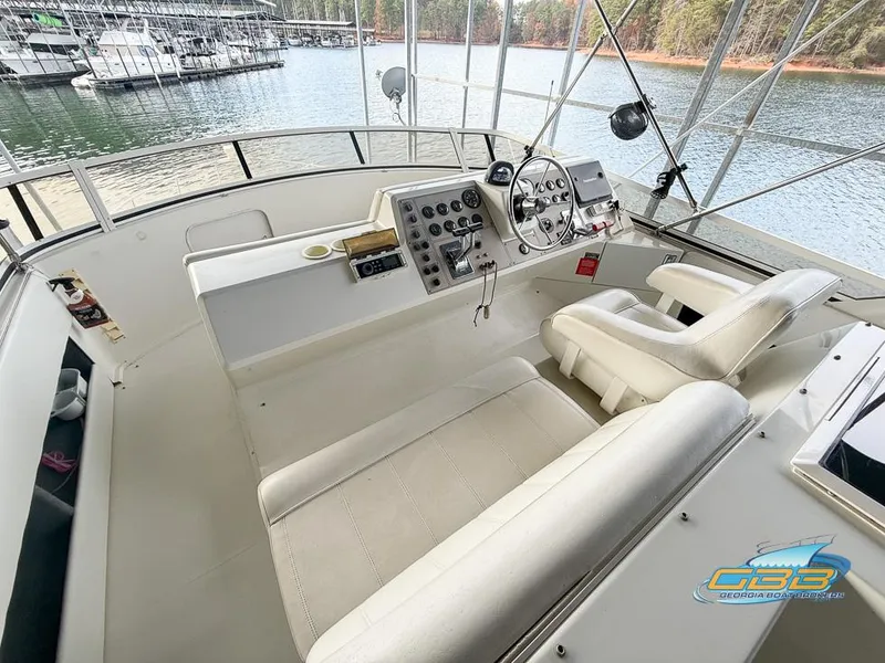 Slide: The Image of 1998 Carver 405 Aft Cabin helm with lake view and marina in background. - 24