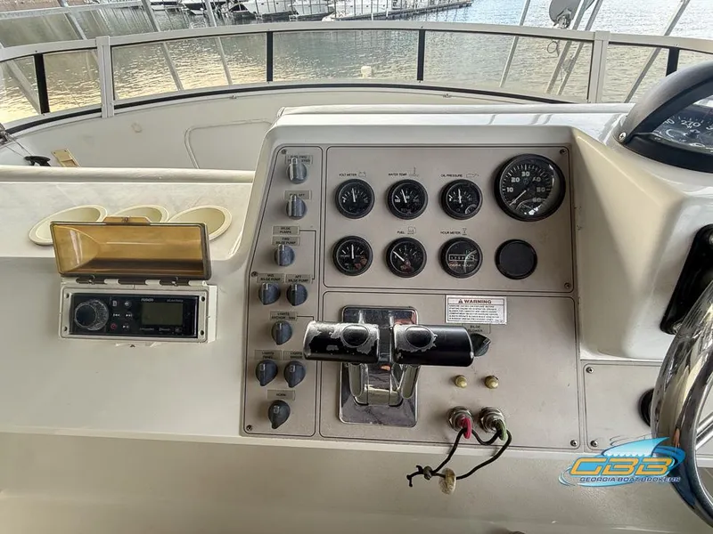 Slide: The Image of 1998 Carver 405 Aft Cabin helm with gauges and controls, docked at marina. - 29