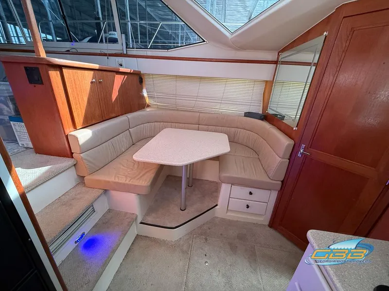 Slide: The Image of 1998 Carver 405 Aft Cabin interior with cozy seating and table. - 39
