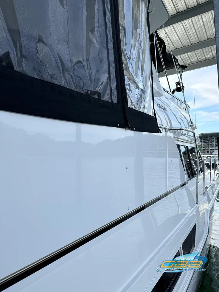 Slide: The Image of 1998 Carver 405 Aft Cabin yacht docked under a covered marina. - 48