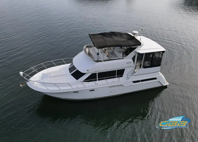 Slide: The Image of 1998 Carver 405 Aft Cabin yacht on calm water, aerial view. - 8