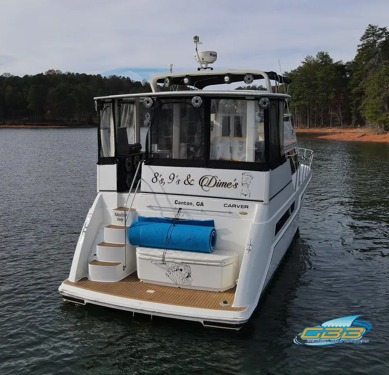 Slide: The Image of 1998 Carver 405 Aft Cabin boat on a lake, rear view with custom name. - 14