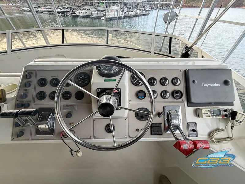 Slide: The Image of 1998 Carver 405 Aft Cabin helm with steering wheel and navigation controls. - 31