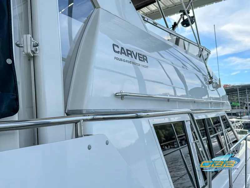 Slide: The Image of 1998 Carver 405 Aft Cabin yacht, sleek design, docked under a canopy. - 47