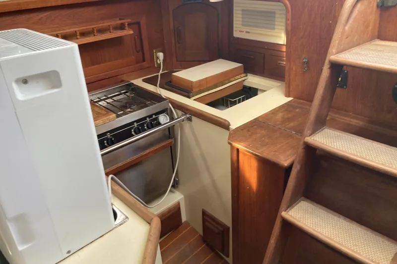 Slide: The Image of Interior of 1994 Pacific Seacraft 37 sailboat galley with stove and wooden cabinetry. - 12