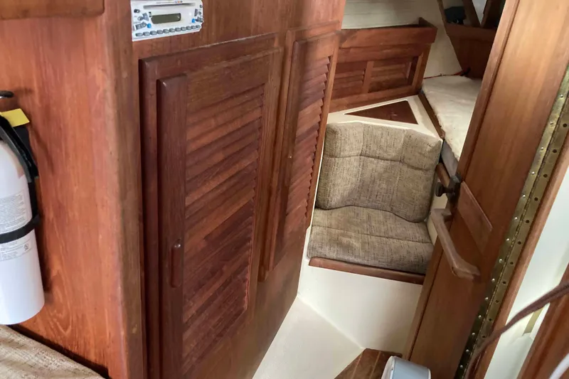 Slide: The Image of Interior of 1994 Pacific Seacraft 37 sailboat with wooden cabinetry and cushioned seating. - 14