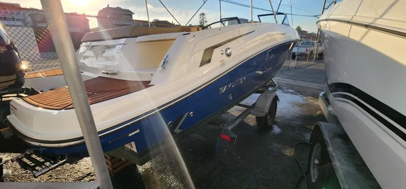 Slide: The Image of 2024 Bayliner VR6 Bowrider OB on trailer, blue and white design, outdoor setting. - 22