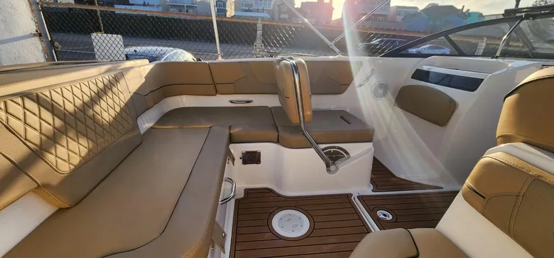 Slide: The Image of 2024 Bayliner VR6 Bowrider OB interior with tan seating and wood flooring. - 25