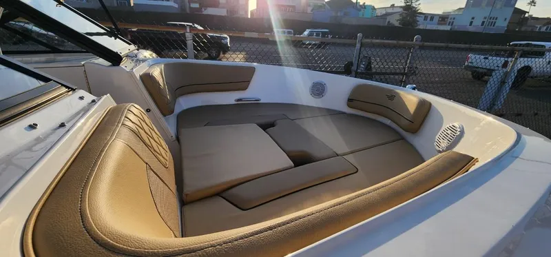 Slide: The Image of 2024 Bayliner VR6 Bowrider OB interior with tan seating, outdoor setting. - 30