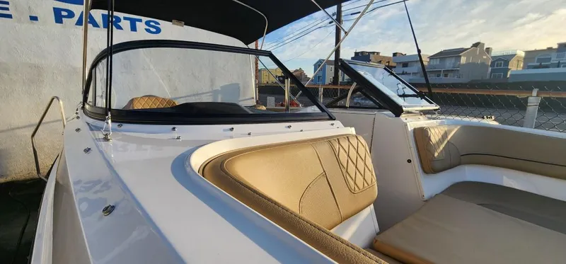 Slide: The Image of 2024 Bayliner VR6 Bowrider OB with tan interior, docked under a clear sky. - 31