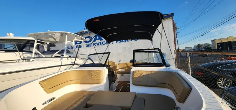Slide: The Image of 2024 Bayliner VR6 Bowrider OB with spacious seating and canopy in a marina setting. - 37