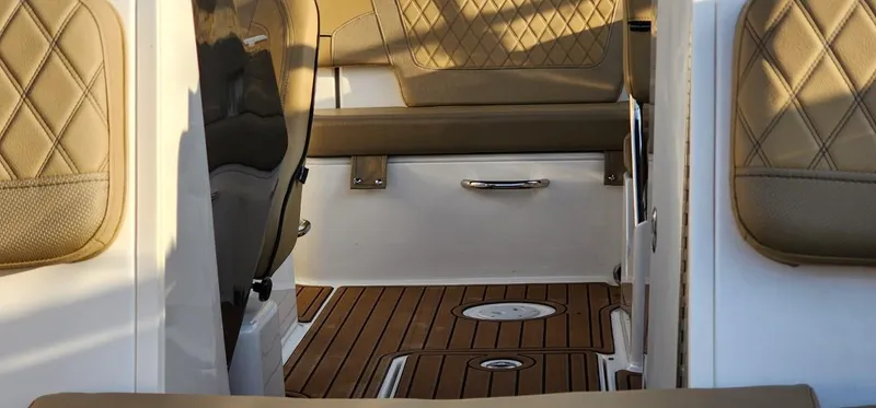 Slide: The Image of 2024 Bayliner VR6 Bowrider OB interior with tan quilted seats and wood-style flooring. - 38