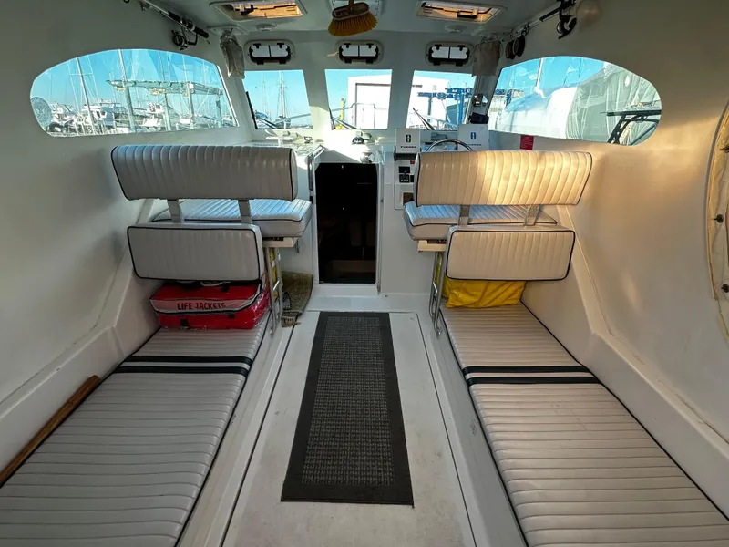 Slide: The Image of 2000 Mainship Pilot 30 Sedan interior with white seating and cockpit view. - 11