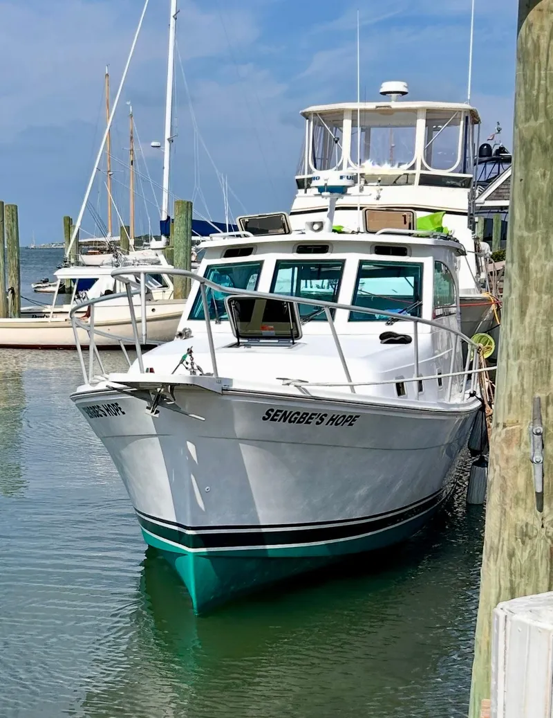 Slide: The Image of 2000 Mainship Pilot 30 Sedan docked in a marina, clear sky background. - 2