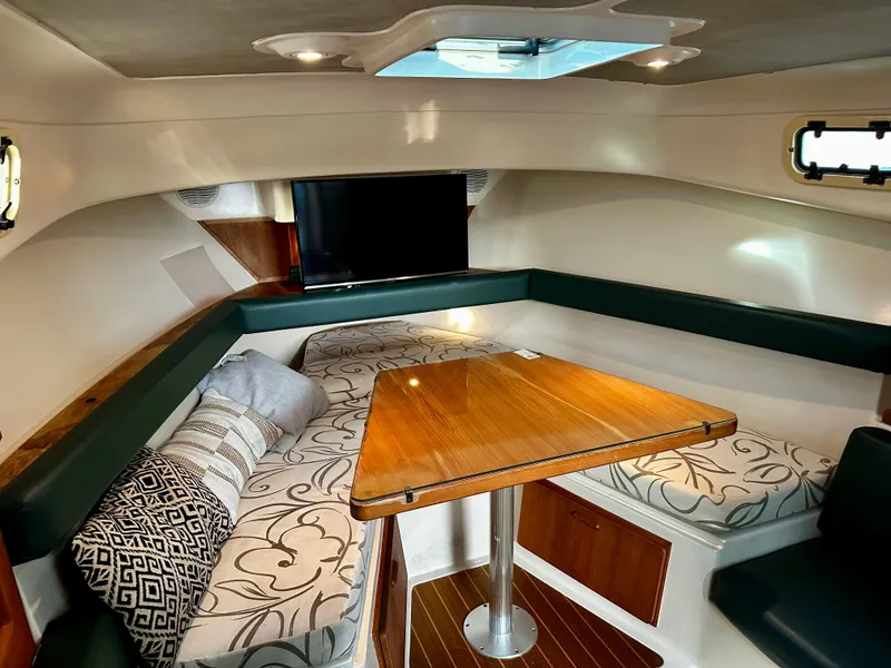 Slide: The Image of Interior of 2000 Mainship Pilot 30 Sedan with cozy seating and wooden table. - 20