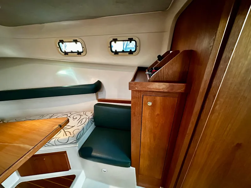 Slide: The Image of Interior of 2000 Mainship Pilot 30 Sedan with wood accents and seating. - 21