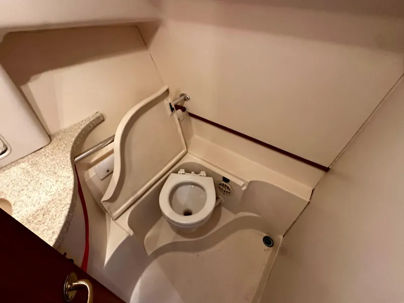 Slide: The Image of Compact bathroom in 2000 Mainship Pilot 30 Sedan boat, featuring a toilet and sink. - 22