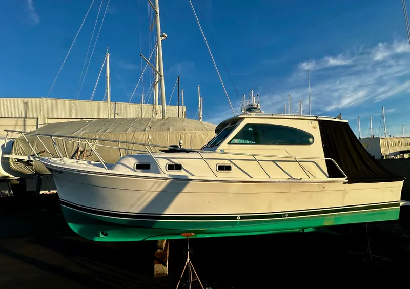 Slide: The Image of 2000 Mainship Pilot 30 Sedan boat on dry dock under clear blue sky. - 24