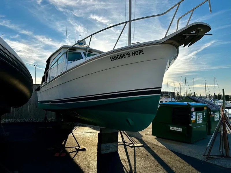 Slide: The Image of 2000 Mainship Pilot 30 Sedan boat named "Sengbe's Hope" on dry dock at marina. - 25