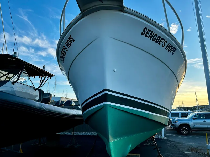 Slide: The Image of 2000 Mainship Pilot 30 Sedan boat named "Sengbe's Hope" docked at marina. - 27