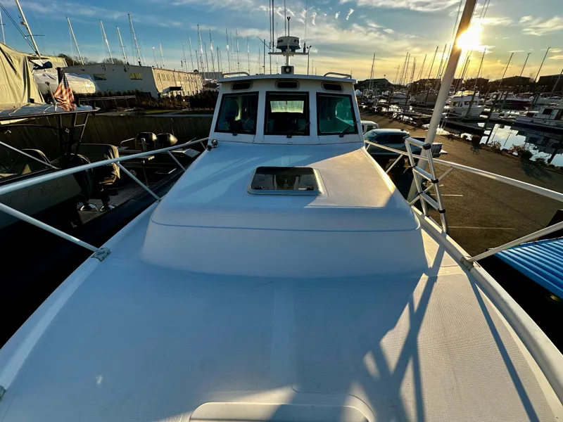 Slide: The Image of 2000 Mainship Pilot 30 Sedan boat docked at marina during sunset. - 3