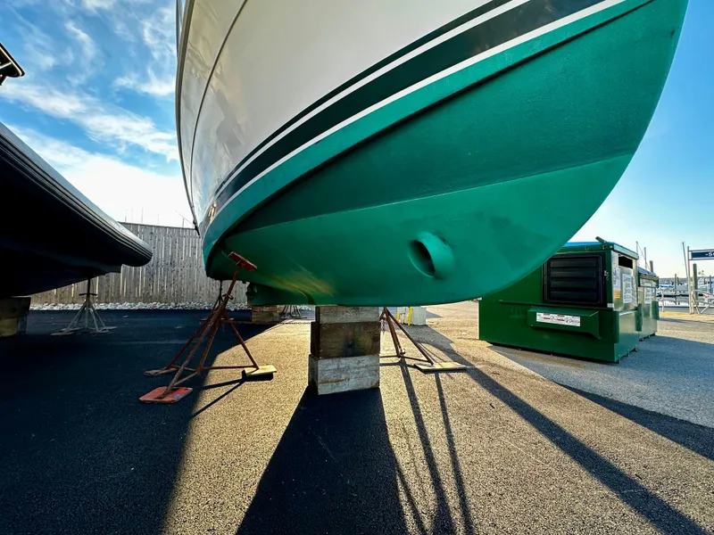 Slide: The Image of 2000 Mainship Pilot 30 Sedan boat on stands, green hull, outdoor storage. - 31