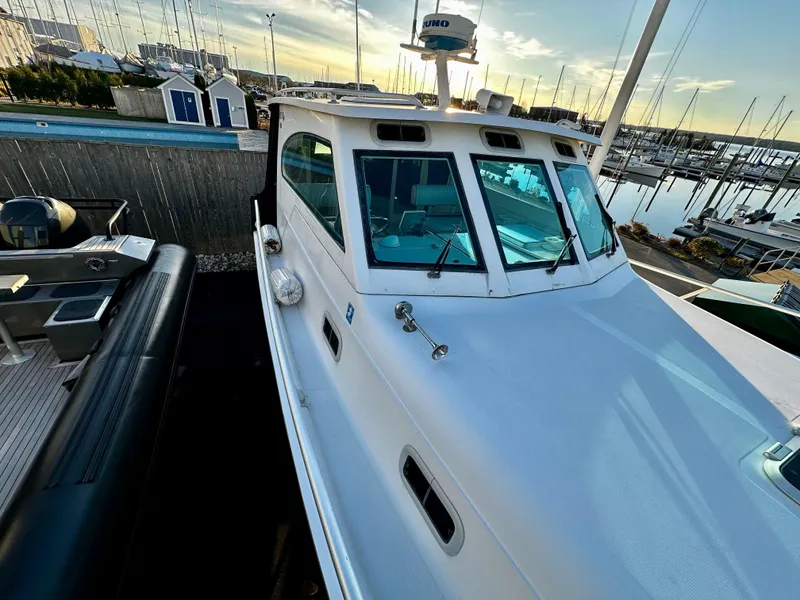 Slide: The Image of 2000 Mainship Pilot 30 Sedan docked at marina during sunset. - 7